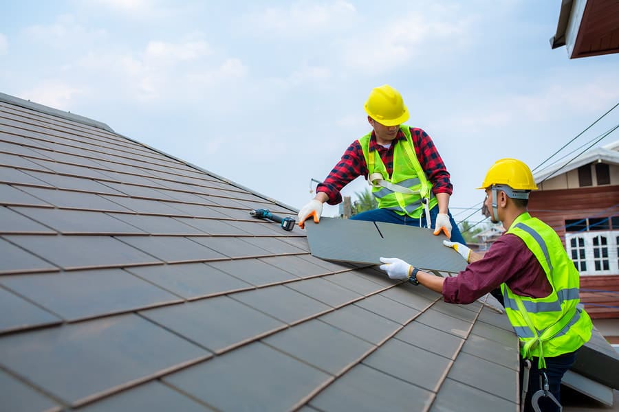 Roofing crew installing shingles